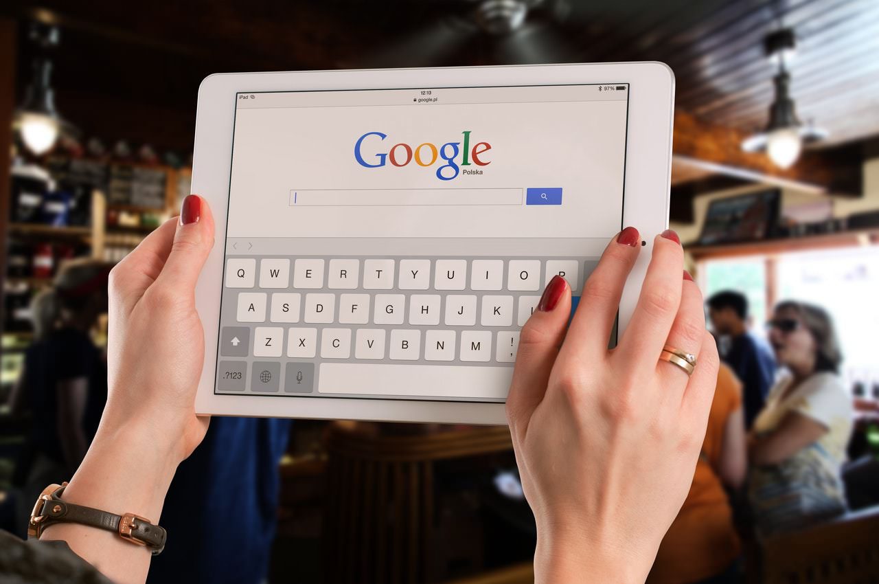 Woman in bar conducting a Google search on a tablet