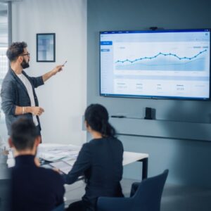 A man presenting business growth to a small team.